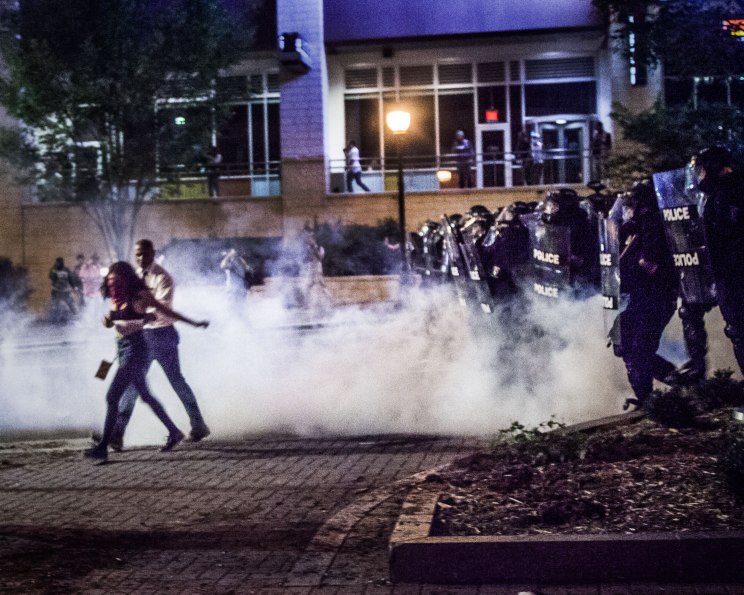 Protesters scurry away from a riot squad 'charge', meant to disperse the crowd. Tear gas was deployed in the road in front of the advancing line. Uptown Charlotte, NC 9/21/16